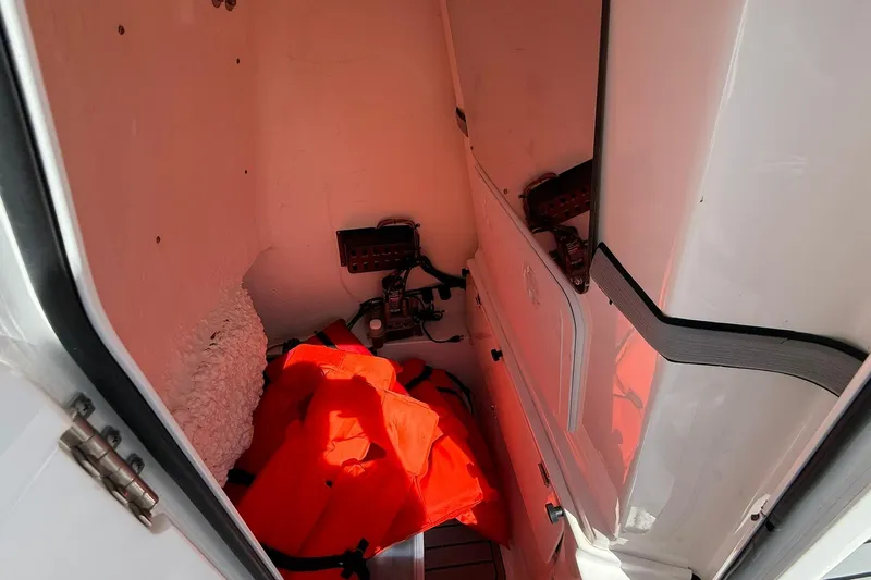 Slide: The Image of 2021 Tidewater 2500 Carolina Bay storage compartment with orange life jackets. - 17