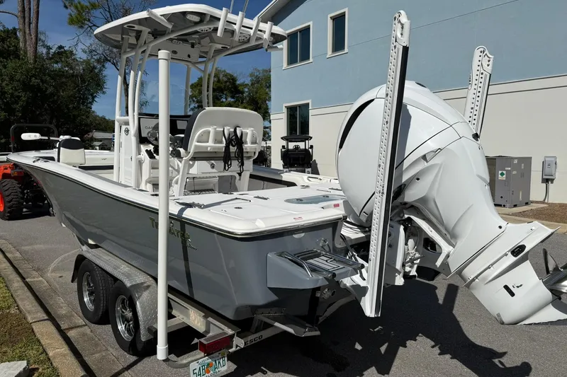 Slide: The Image of 2021 Tidewater 2500 Carolina Bay boat on trailer, featuring a powerful outboard motor. - 4