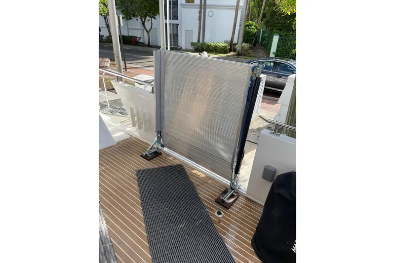 Slide: The Image of Teak gangway on 1995 JOHNSON 65 Flybridge Motoryacht, with inflatable boat in background. - 16