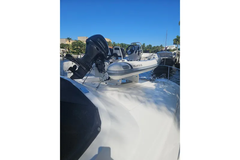 Slide: The Image of 1995 Johnson Flybridge Motoryacht with Highfield tender and Yamaha outboard motor, docked in sunny marina. - 173
