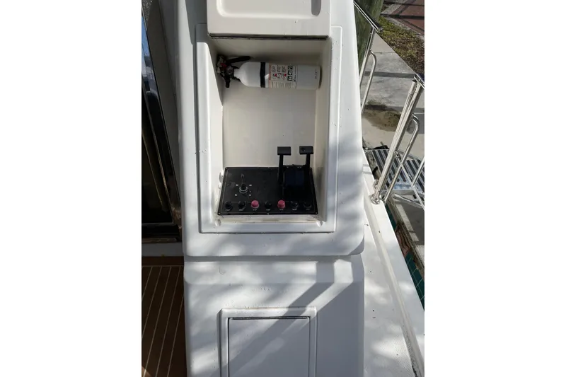 Slide: The Image of Luxurious 1995 JOHNSON 65 Flybridge Motoryacht deck with wicker seating and scenic water view. - 23