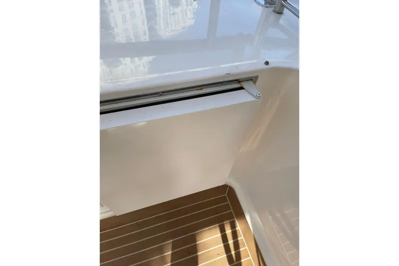 Slide: The Image of Flybridge motoryacht sink area on 1995 JOHNSON 65, featuring wooden deck and storage cabinet. - 35