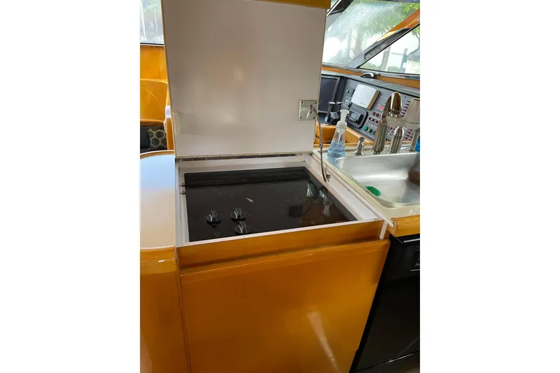 Slide: The Image of Open cabinet in 1995 JOHNSON 65 Flybridge Motoryacht kitchen, showing storage and utensils. - 77