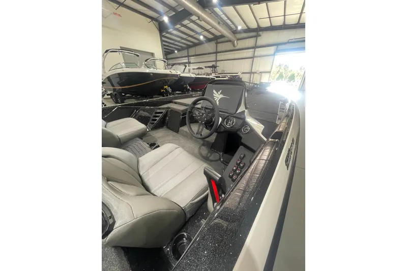 Slide: The Image of 2026 Skeeter ZXR20 SE boat interior with steering wheel and seats in a showroom. - 15