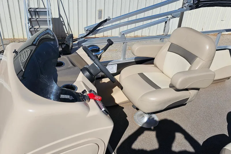 Slide: The Image of 2016 Sun Tracker Fishin' Barge 22 DLX helm with beige captain's chair and steering console. - 12