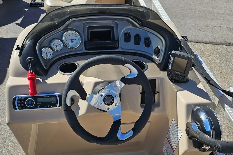 Slide: The Image of 2016 Sun Tracker Fishin' Barge 22 DLX dashboard with steering wheel and control panel. - 13