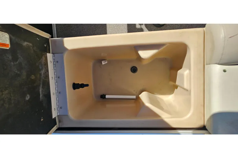 Slide: The Image of 2016 Sun Tracker Fishin' Barge 22 DLX livewell interior, beige with drain and fittings. - 21