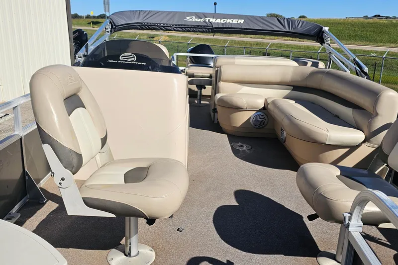 Slide: The Image of 2016 Sun Tracker Fishin' Barge 22 DLX interior with beige seating and canopy. - 6