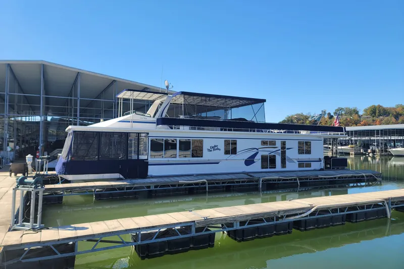 The Image of 2002 Fantasy 16 X 68 houseboat docked at marina under clear blue sky. - 0