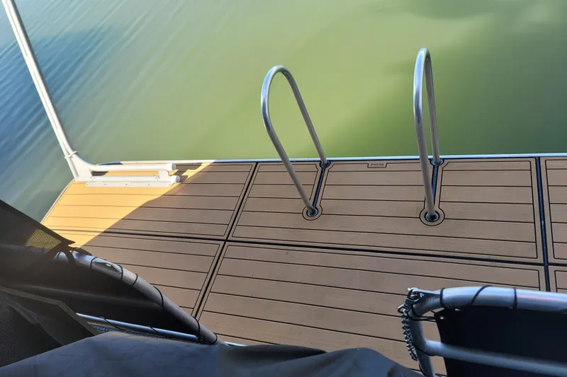 Slide: The Image of Houseboat deck with swim ladder, overlooking calm green water. - 10