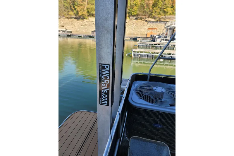 Slide: The Image of Houseboat deck with PWCrails.com post and Carrier air conditioning unit, docked by calm water. - 14