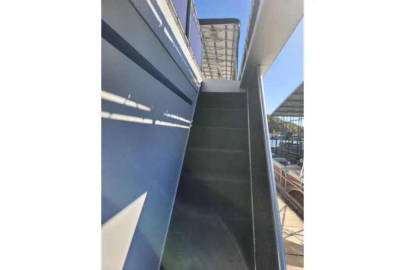 Slide: The Image of Staircase on a 2002 Fantasy 16 X 68 Houseboat, docked under clear skies. - 17