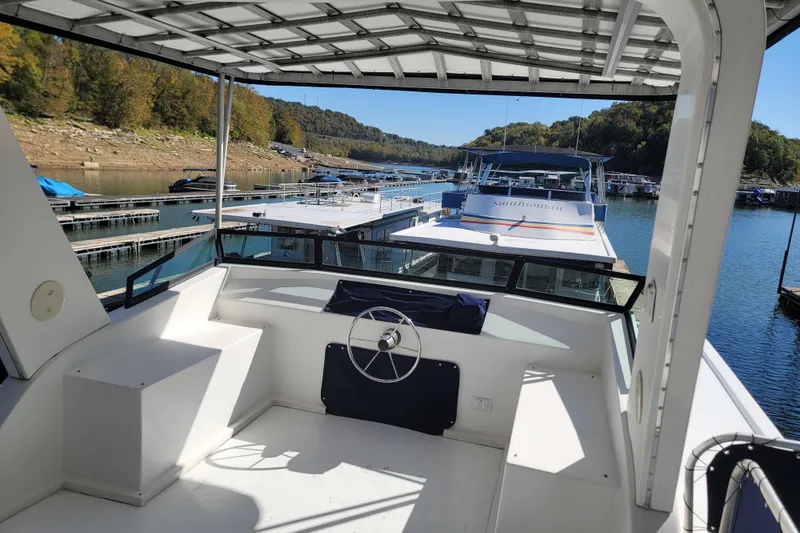 Slide: The Image of 2002 Fantasy 16 X 68 Houseboat docked on a scenic lake with surrounding trees. - 19