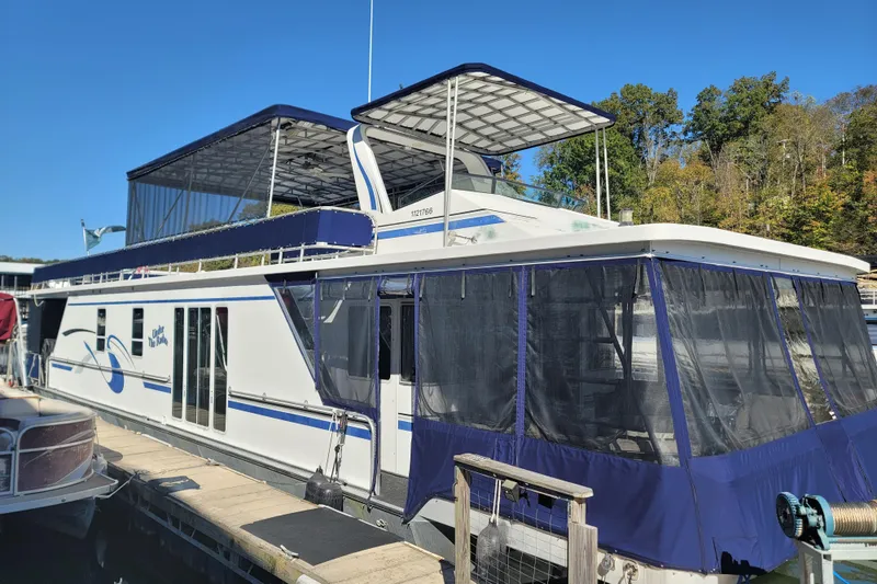 Slide: The Image of 2002 Fantasy 16 X 68 houseboat docked, featuring blue accents and upper deck canopy. - 4
