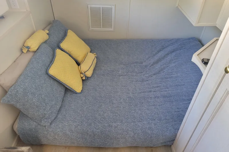 Slide: The Image of Cozy bedroom in 2002 Fantasy 16 X 68 houseboat with blue bedding and yellow pillows. - 40