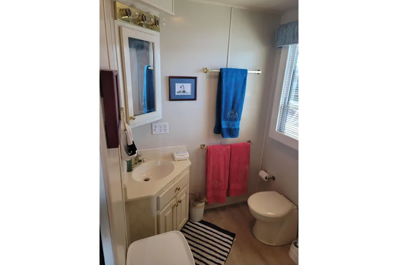 Slide: The Image of Small bathroom in 2002 Fantasy 16 X 68 houseboat with sink, toilet, and colorful towels. - 45