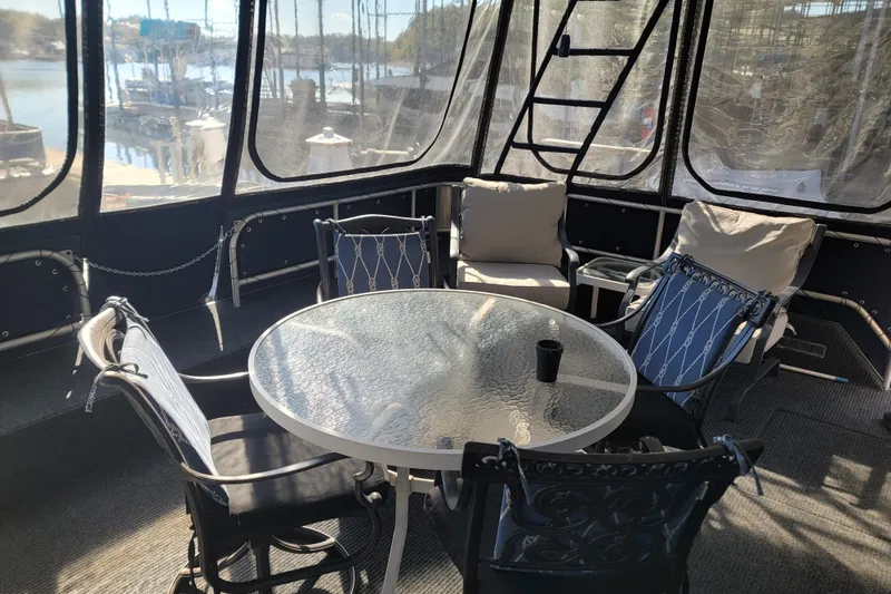 Slide: The Image of Enclosed deck area on 2002 Fantasy 16 X 68 Houseboat with seating and glass table. - 6