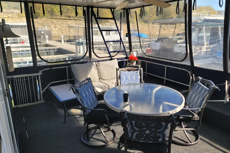 Slide: The Image of Cozy 2002 Fantasy 16 X 68 houseboat interior with seating and table on a sunny day. - 7