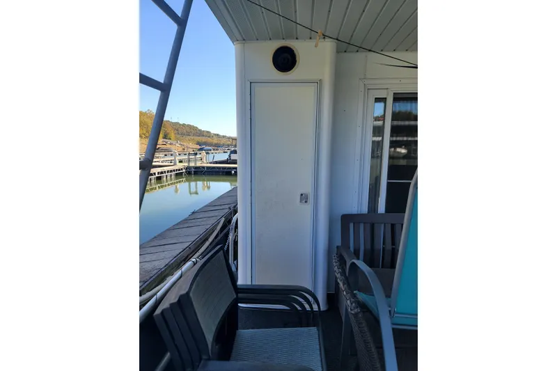 Slide: The Image of 2002 Fantasy 16 X 68 Houseboat deck with seating, docked by calm water. - 9