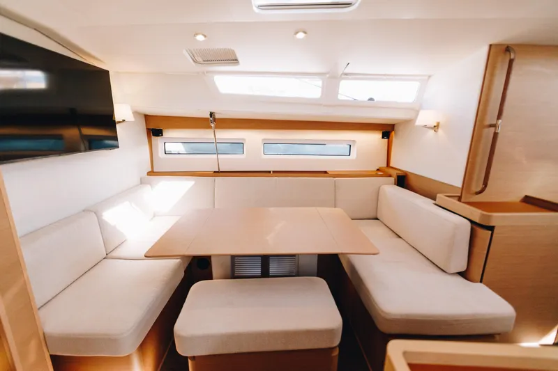 Slide: The Image of Luxurious interior of 2023 Jeanneau Sun Odyssey 490 yacht with elegant seating and table. - 19