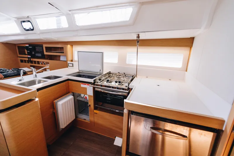 Slide: The Image of Modern kitchen interior of 2023 Jeanneau Sun Odyssey 490 yacht, featuring stove and sink. - 37