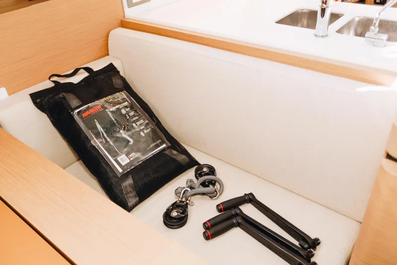 Slide: The Image of Jeanneau Sun Odyssey 490 interior with tools and accessories on a cushioned seat. - 40