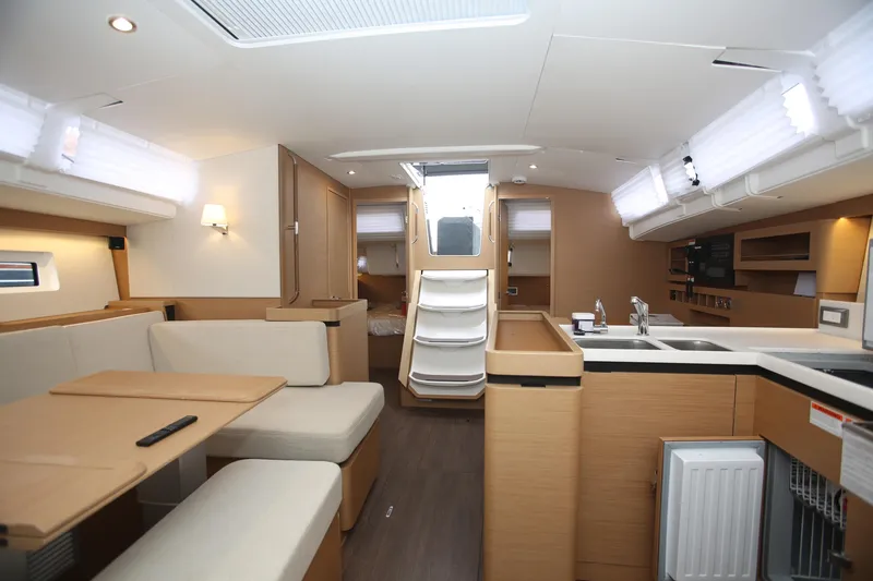 Slide: The Image of 2023 Jeanneau Sun Odyssey 490 sailboat with inflatable dinghy on deck, docked at marina. - 7