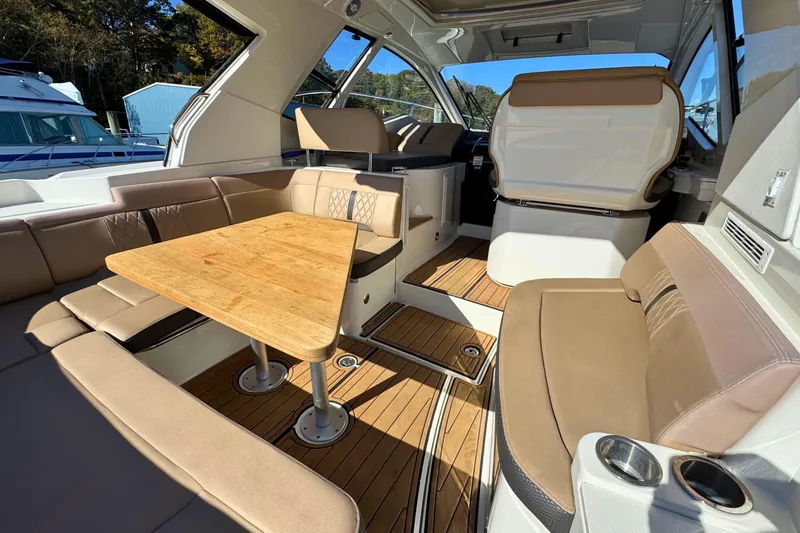 Slide: The Image of 2017 Sea Ray Sundancer 350 Coupe interior with elegant seating and wooden table. - 12
