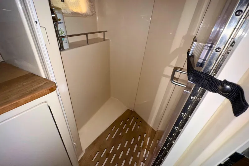 Slide: The Image of 2017 Sea Ray Sundancer 350 Coupe shower area with wooden flooring and storage shelf. - 24