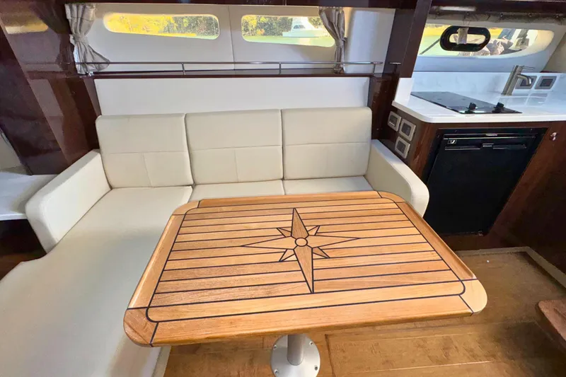 Slide: The Image of Interior of 2017 Sea Ray Sundancer 350 Coupe with elegant seating and wooden table. - 25