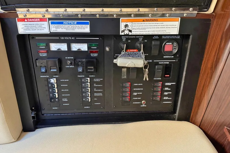 Slide: The Image of Electrical control panel of 2017 Sea Ray Sundancer 350 Coupe with safety warnings and switches. - 28