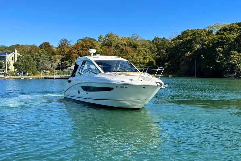 Slide: The Image of 2017 Sea Ray Sundancer 350 Coupe cruising on a serene lake with lush green surroundings. - 3