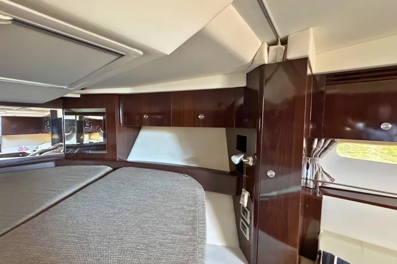 Slide: The Image of 2017 Sea Ray Sundancer 350 Coupe interior cabin with wood finish and cozy bedding. - 32