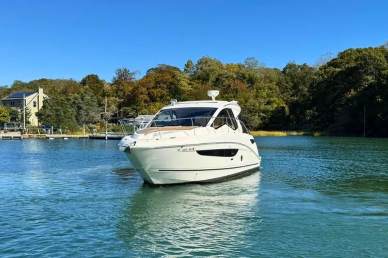 Slide: The Image of 2017 Sea Ray Sundancer 350 Coupe cruising on a serene lake with lush greenery. - 4