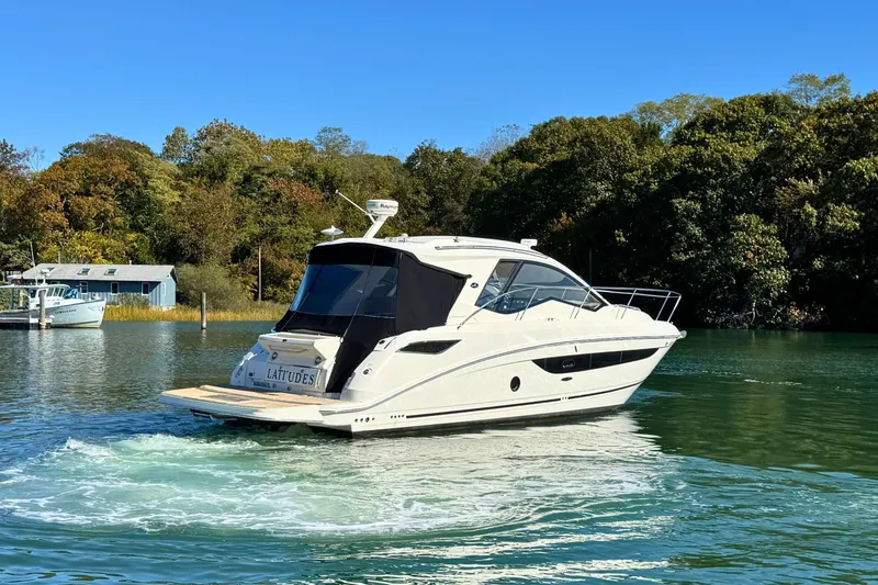 Slide: The Image of 2017 Sea Ray Sundancer 350 Coupe cruising on a serene lake with lush greenery. - 5