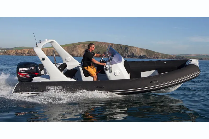 Slide: The Image of 2019 Brig Eagle 650 inflatable boat with canopy, displayed indoors on a trailer. - 17