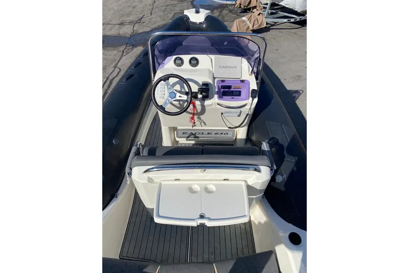 Slide: The Image of 2019 Brig Eagle 650 boat interior with seating and console, docked outdoors. - 5