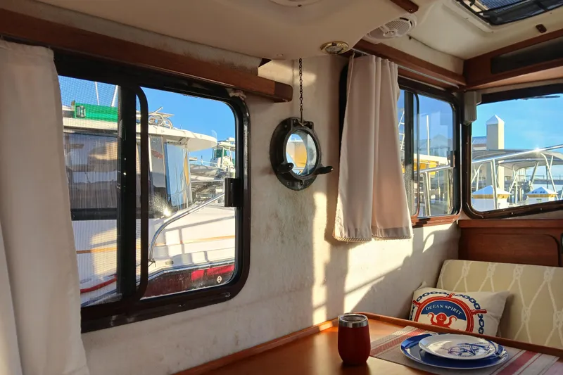 Slide: The Image of Interior of 2009 Ranger Tugs R-25 boat with windows, curtains, and nautical decor. - 10