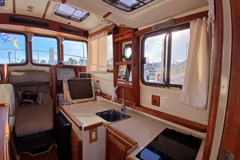 Slide: The Image of Interior of 2009 Ranger Tugs R-25 boat with kitchenette and navigation equipment. - 14