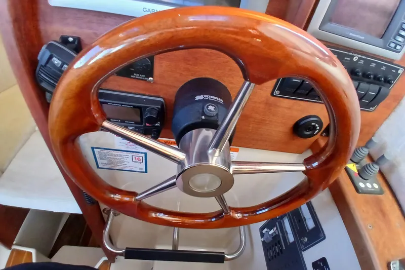 Slide: The Image of 2009 Ranger Tugs R-25 boat helm with wooden steering wheel and control panel. - 28