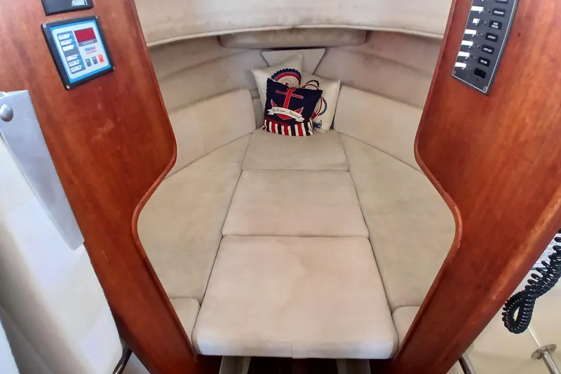 Slide: The Image of 2009 Ranger Tugs R-25 cabin interior with cushioned seating and nautical-themed pillows. - 36