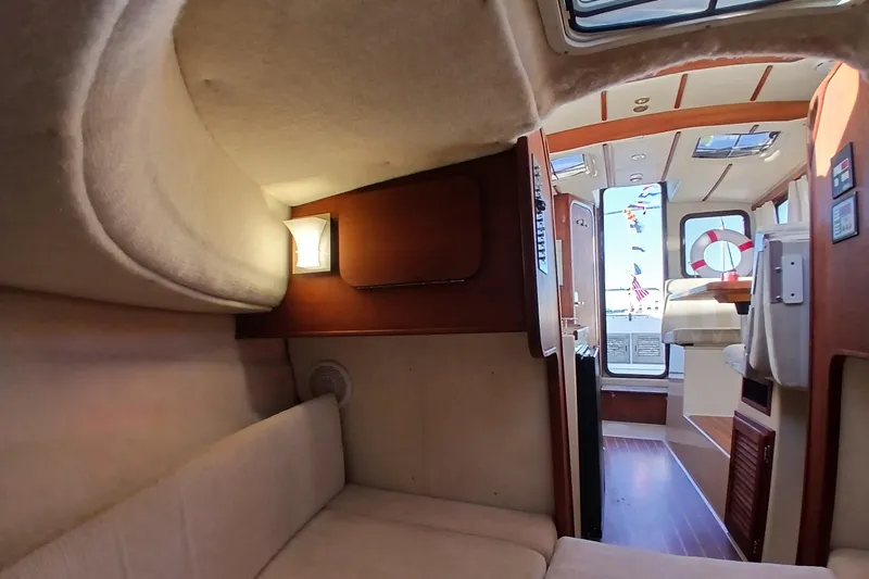 Slide: The Image of Interior of 2009 Ranger Tugs R-25 boat, featuring cozy seating and elegant wood finishes. - 39