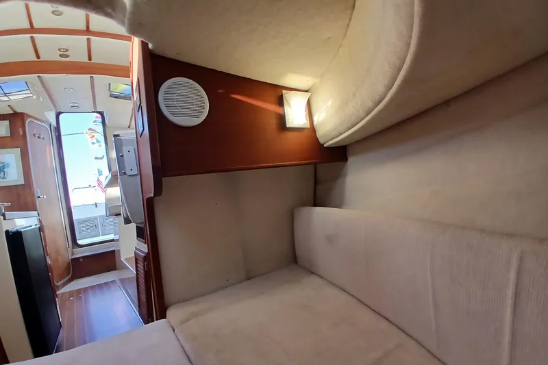Slide: The Image of Interior of 2009 Ranger Tugs R-25 boat, featuring cozy seating and wooden accents. - 40