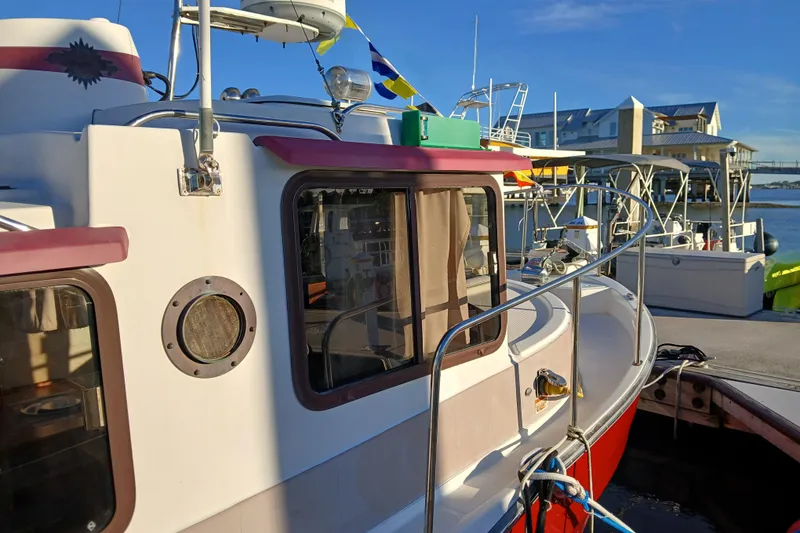 Slide: The Image of 2009 Ranger Tugs R-25 boat docked at marina, featuring classic design and vibrant colors. - 47