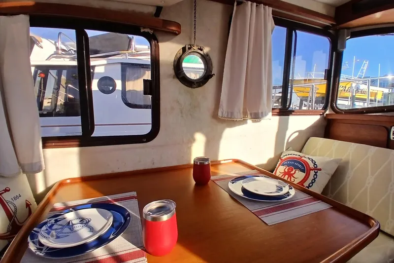 Slide: The Image of Cozy interior of 2009 Ranger Tugs R-25 with nautical-themed dining setup. - 6