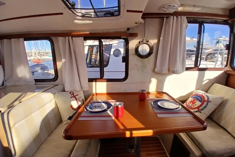 Slide: The Image of Interior of 2009 Ranger Tugs R-25 with dining area, nautical decor, and marina view. - 7