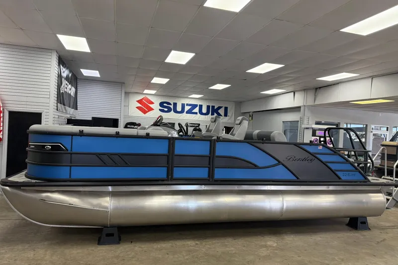 Slide: The Image of 2026 Bentley Pontoons Elite 223 Swingback in showroom, featuring sleek blue design. - 2
