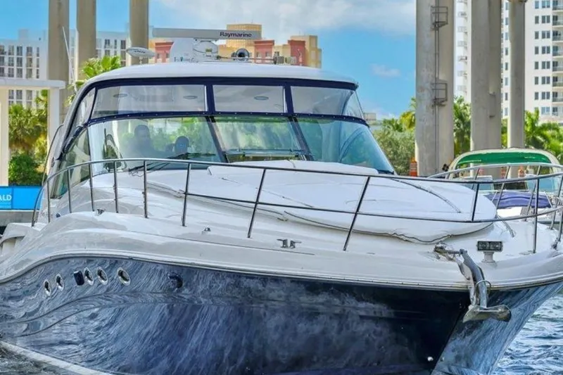 The Image of 2006 Sea Ray 500 Sundancer yacht docked in a marina with cityscape background. - 1