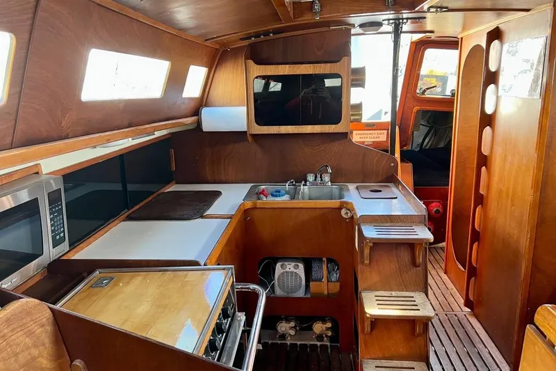 Slide: The Image of Interior of 1982 Santa Cruz 50 sailboat with wooden cabinetry and kitchen amenities. - 10