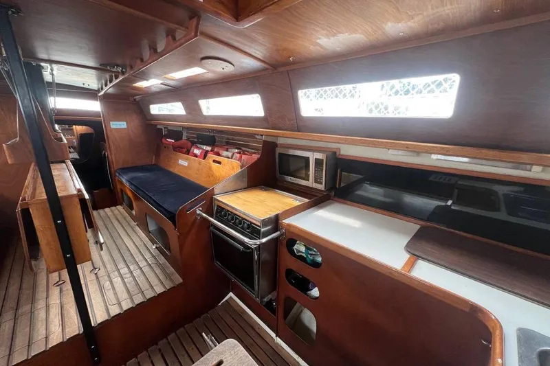Slide: The Image of Interior of a 1982 Santa Cruz 50 sailboat with wooden finishes and kitchen amenities. - 11
